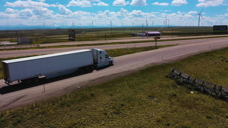 Aerial-view-around-a-semi-truck-driving-on-the-American-Freeway-in-sunny-USA