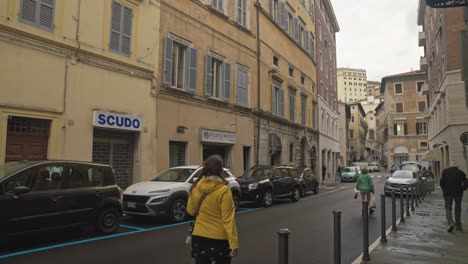 A-lone-female-tourist-walks-the-quiet-back-streets-of-the-city-of-Perugia,-Province-of-Perugia,-Italy