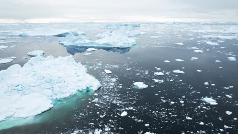 Floating-frozen-iceberg-in-deep-ocean,-aerial-view