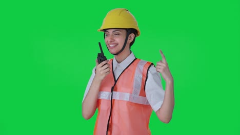 Happy-Indian-female-architect-giving-instructions-on-walkie-talkie-Green-screen