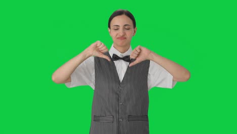 Disappointed-Indian-woman-waiter-showing-thumbs-down-to-customer-Green-screen