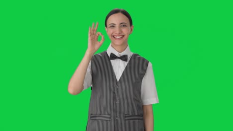 Happy-Indian-woman-waiter-showing-okay-sign-Green-screen