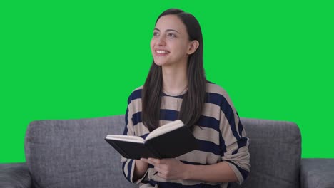 Happy-and-cute-Indian-girl-writing-a-book-Green-screen