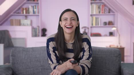Happy-Indian-girl-laughing-while-watching-TV