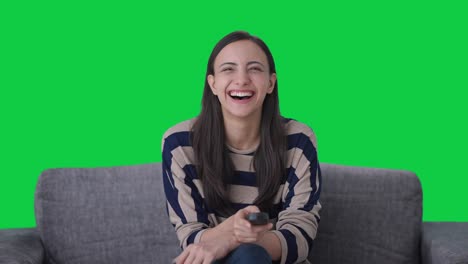Happy-Indian-girl-laughing-while-watching-TV-Green-screen