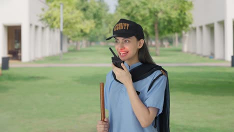 Happy-Indian-female-security-guard-talking-through-walkie-talkie