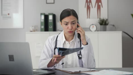 Stressed-Indian-female-doctor-explaining-X-ray-report-to-patient-on-call