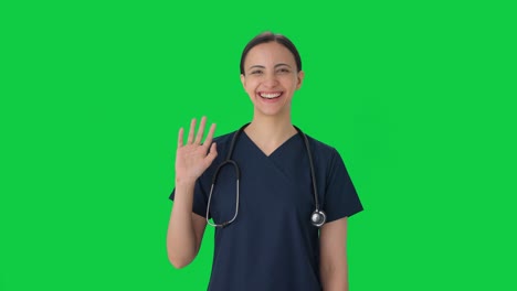 Happy-Indian-female-doctor-waving-Hi-Green-screen