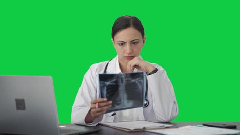 Confused-Indian-female-doctor-checking-X-ray-test-Green-screen