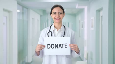 Happy-Indian-female-doctor-holding-DONATE-banner