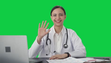 Happy-Indian-female-doctor-waving-Hi-Green-screen