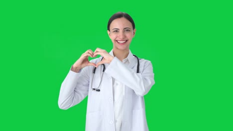 Fröhliche-Indische-Ärztin-Zeigt-Herzzeichen-Auf-Grünem-Bildschirm