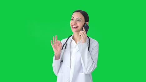 Happy-Indian-female-doctor-talking-to-someone-on-call-Green-screen