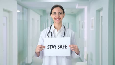 Happy-Indian-female-doctor-holding-STAY-SAFE-banner