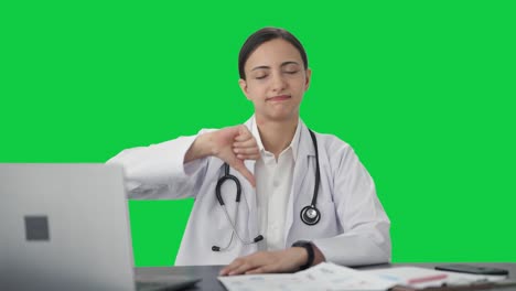 Verärgerte-Indische-Ärztin-Zeigt-Daumen-Nach-Unten-Auf-Grünem-Bildschirm