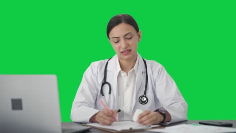 Sad-Indian-female-doctor-giving-medicine-to-patient-Green-screen