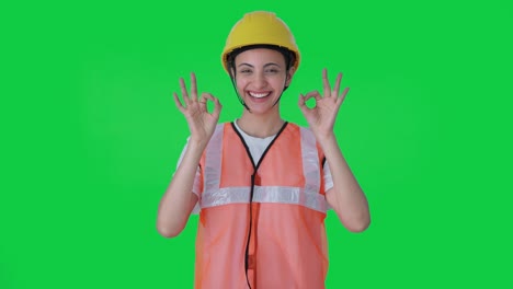 Happy-Indian-female-construction-worker-showing-okay-sign-Green-screen