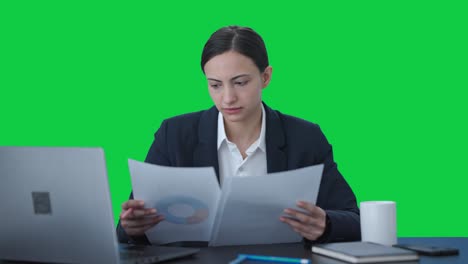 Serious-Indian-business-woman-checking-reports-Green-screen