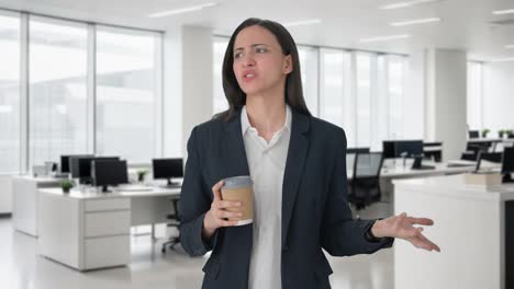 Angry-Indian-female-manager-waiting-for-someone-and-drinking-coffee