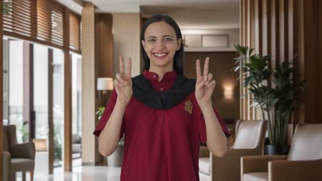 Happy-Indian-female-housekeeper-showing-victory-sign