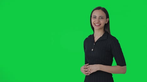 Happy-Indian-female-journalist-pointing-at-blank-green-screen
