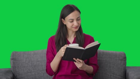 Happy-Indian-woman-reading-a-book-and-enjoying-coffee-Green-screen