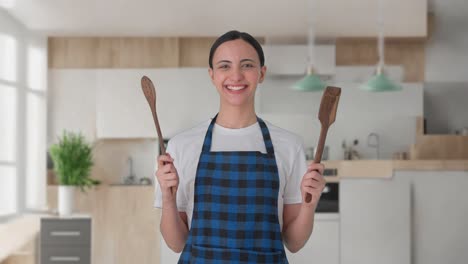 Happy-Indian-housewife-posing-with-spoon-and-spatula