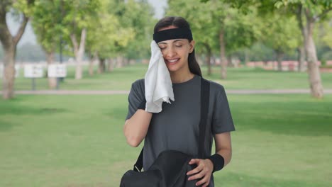 Happy-Indian-girl-taking-out-towel-from-duffel-bag