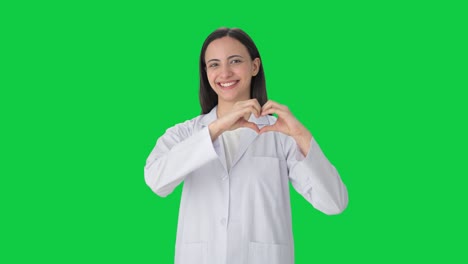 Happy-Indian-female-scientist-showing-heart-sign-Green-screen