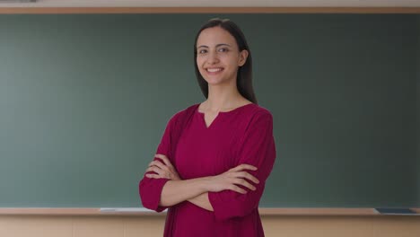 Portrait-of-Happy-Indian-female-teacher-standing-crossed-hands