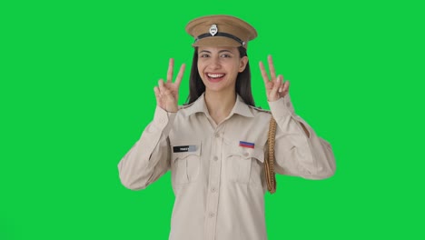 Happy-Indian-female-police-officer-showing-victory-sign-Green-screen