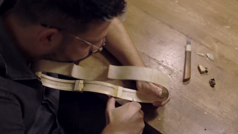 Luthier-creating-violin-ribs-in-workshop