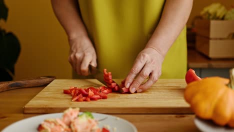 Crop-anonymous-woman-chopping-red-bell-pepper-on-cutting-board