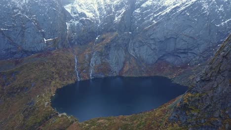 Crater-lake-surrounded-by-massive-rocky-mountains-in-Norway