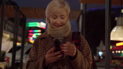 Woman-using-mobile-phone-on-night-street
