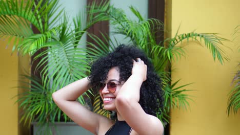 Cheerful-Latin-American-woman-in-sunglasses-shaking-head