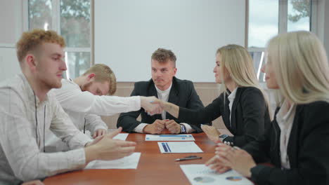 Geschäftsverhandlungen-Im-Konferenzsaal,-Menschen-Schütteln-Sich-Die-Hände-Und-Sitzen-An-Einem-Langen-Tisch