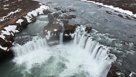 Scenic-waterfall-streaming-from-rocky-cliff-on-winter-day
