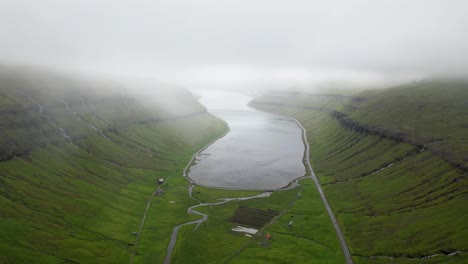 Green-fjord-with-roads-against-cloudy-sky