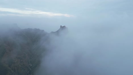 Ruins-on-mountain-peak-above-clouds-on-foggy-day
