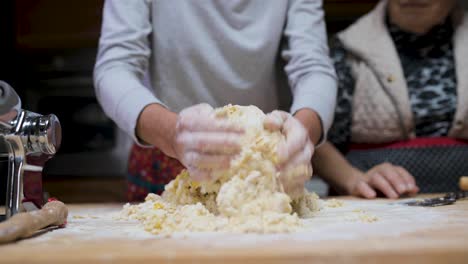 Crop-woman-preparing-dough-at-table-in-kitchen