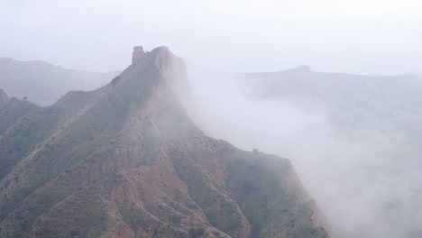 Mountain-ridge-near-river-on-foggy-day