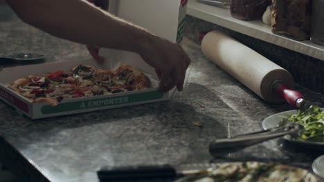 Cook-preparing-pizza-for-delivery-on-kitchen