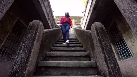 Mujer-Alegre-Caminando-Por-Las-Escaleras-De-La-Casa-Antigua