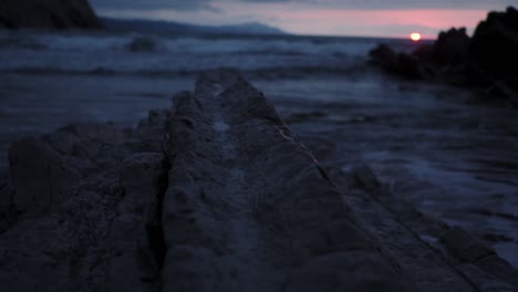 Rocky-seashore-with-waves-at-sunset
