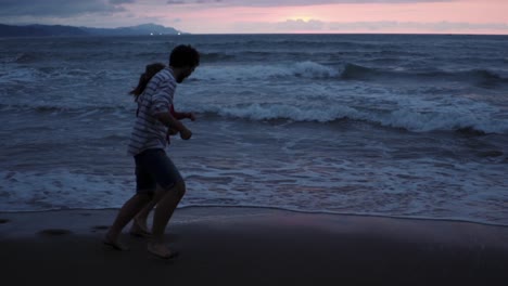 Happy-couple-running-on-evening-beach