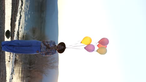 Positive-Frau-Tanzt-Mit-Luftballons-In-Der-Nähe-Des-Sees