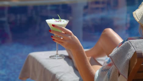 Anonyme,-Stilvolle-Frau-Entspannt-Sich-Auf-Der-Sonnenliege-Am-Pool-Und-Trinkt-Einen-Cocktail