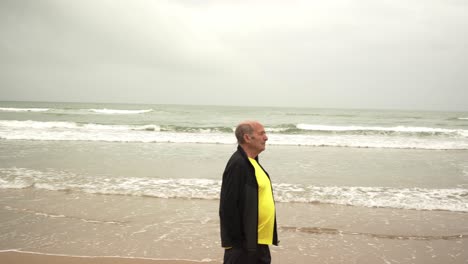Senior-male-athlete-walking-near-sea