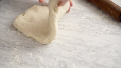Anonymous-woman-rolling-dough-for-pizza